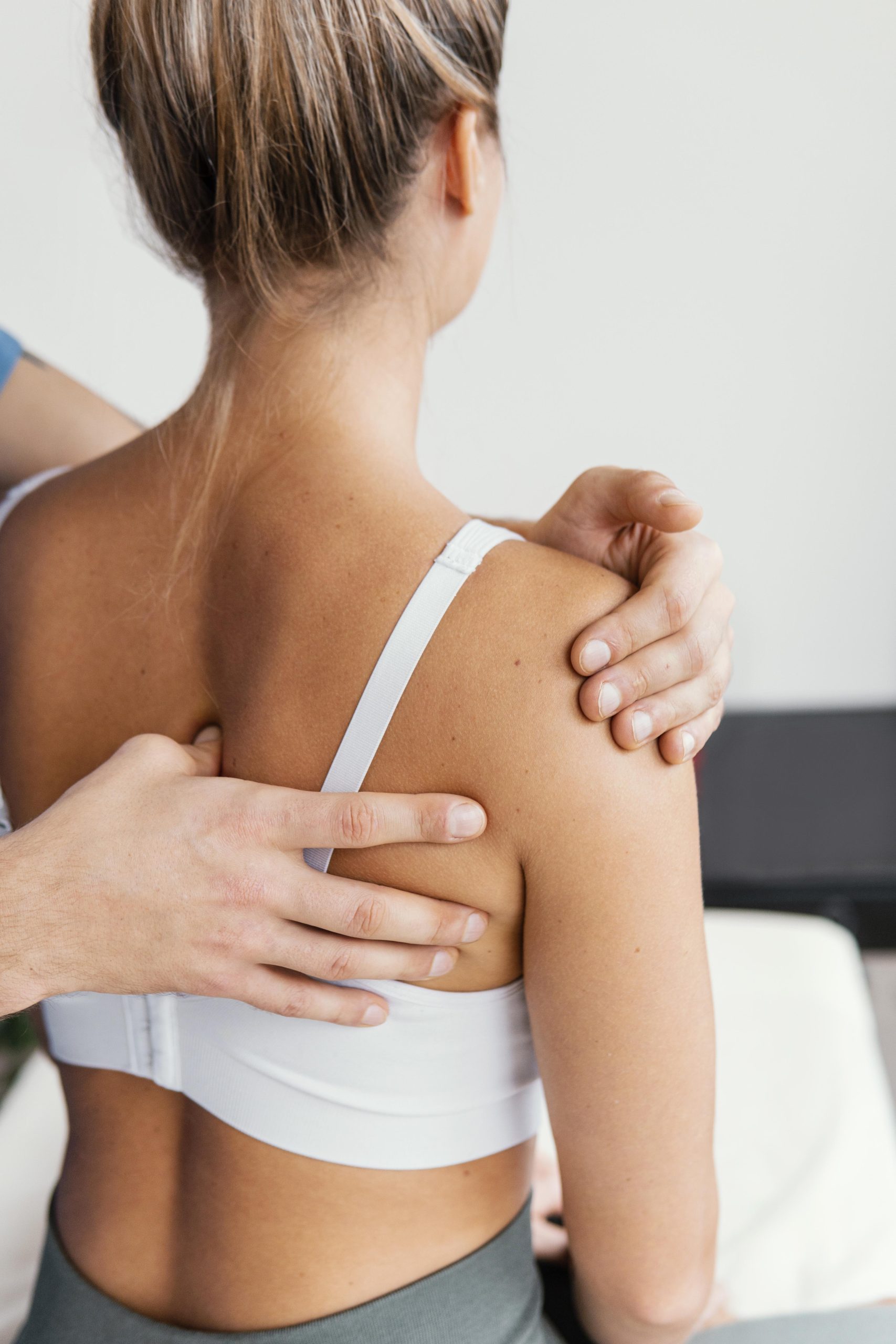 male-osteopathic-doctor-checking-female-patient-s-scapula